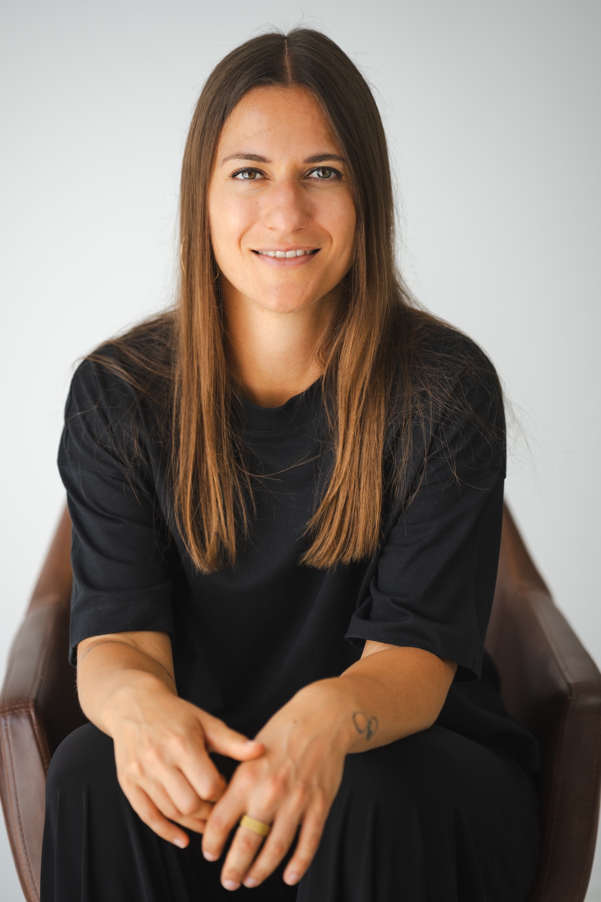 Die DGSv-Supervisorin Giulia Barile sitzt auf einem braunen Stuhl und schaut in die Kamera