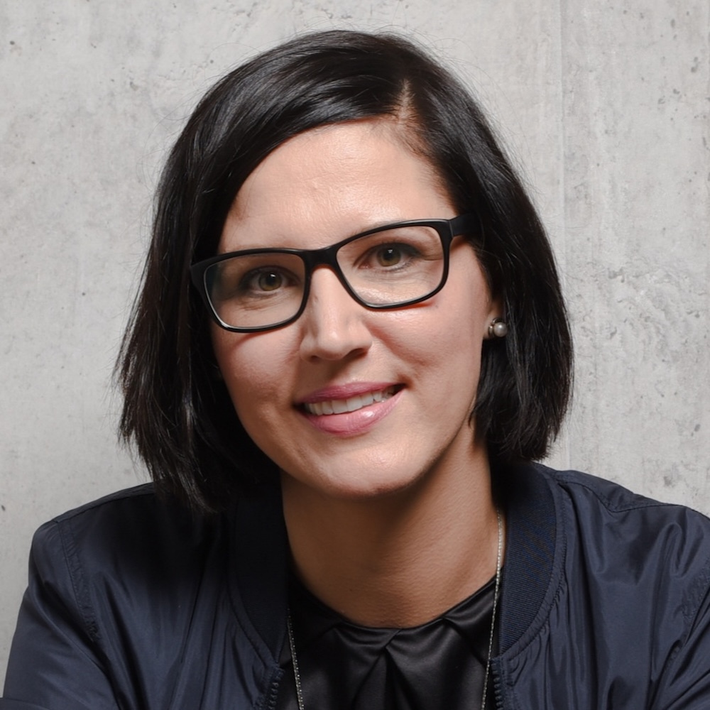 Portrait von Julia, Teilnehmerin des Online-Programms Mit Klarheit in deine berufliche Zukunft. Sie trägt eine Brille mit schwarzem Rand und ein schwarzes Shirt und Jacke.