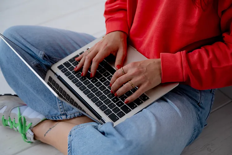 Giulia Barile, DGSv-zertifizierte systemische Supervisorin und Coach und Mentorin für Frauen in der beruflichen Neuorientierung sitzend mit ihrem Laptop auf dem Schoß während sie die Online Supervisionsgruppe für selbstständige Frauen durchführt